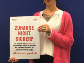 Gleichstellungsbeauftragte Sybille Lüdecke mit einem Plakat der Initiative „Zuhause nicht sicher?“.