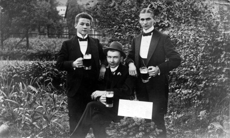 Historisches Foto von drei Männern in Anzügen mit Biergläsern in den Händen