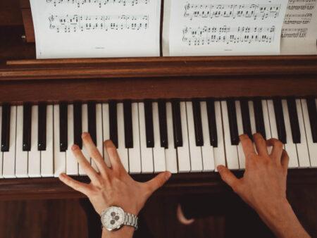 Klavierspielende Hände und Notenblatt
