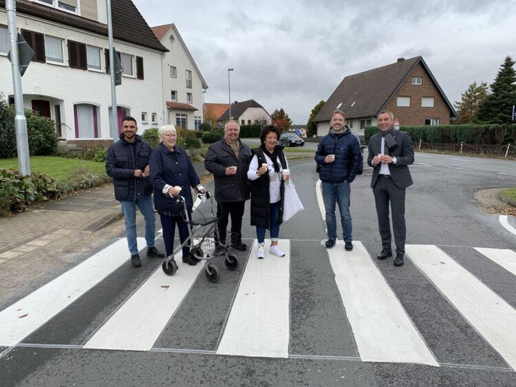 V.l. Sadik Cakmak (Fachdienstleitung Tiefbau), Annemarie Göthel (Bewohnerbeiratsmitglied im Stift), Dieter Nietzold (Bewohnerbeiratsvorsitzender), Renate Claus (Bewohnerbeirat), Sebastian Hokamp (Ortsausschussvorsitzender OA Wüsten) und Bürgermeister Dirk Tolkemitt stoßen gemeinsam auf die neue Querungshilfe an. // Foto: Stadt Bad Salzuflen