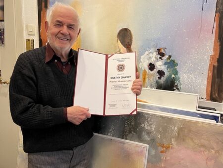 Redzep Memisevic hält eine Urkunde in die Kamera und lächelt